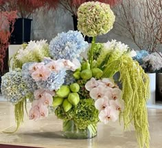 a vase filled with lots of flowers on top of a table