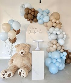 a teddy bear sitting in front of balloons