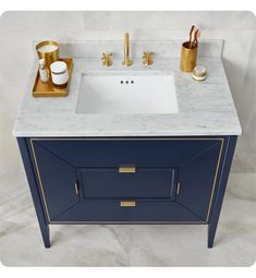 a bathroom vanity with marble counter top and gold faucets on the sink area