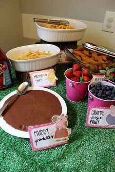 a table topped with lots of food and desserts on top of green carpeted ground