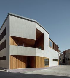 the building is made out of concrete and has wooden slats on it's sides