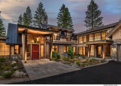 a large house with lots of windows and trees in the background