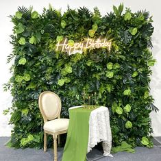 a chair and table in front of a green wall with happy birthday written on it