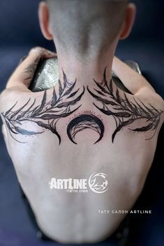 the back of a man's neck with an artistic tattoo design on his chest