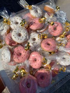 pink and white doughnuts with gold sprinkles in plastic wrappers