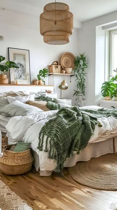 a bedroom with white walls and wooden floors has plants on the shelves above the bed