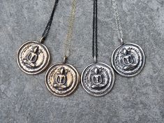 "Thai Buddha Coin Necklace These funky pendants will become your new favorite everyday piece of jewelry! They are modeled after an antique Buddha coin I've had for many years and have cherished. You can customize your necklace by choosing the pendant metal, chain color and length. All pendants are antiqued with a black patina to keep the antique and rustic feel. The original prototype was first carved out of bronze metal clay and then fired in a kiln until only solid metal remained. Each of thes Spiritual Black Coin Pendant Jewelry, Black Spiritual Jewelry With Coin Pendant, Black Spiritual Necklace With Coin Pendant, Spiritual Necklace With Antique Finish Round Pendant, Spiritual Necklaces With Antique Finish Round Pendant, Spiritual Antique Finish Round Pendant Necklace, Spiritual Round Pendant Necklace With Antique Finish, Black Spiritual Jewelry With Antique Finish, Symbolic Pendant Necklaces With Antique Finish