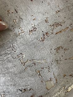 a person's hand is touching the surface of a dirty bowl with dirt on it