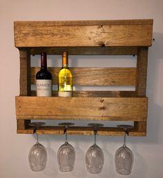 three wine glasses are hanging from a wooden rack with four wine glasses on the bottom