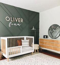 a baby's room with an olive green wall and white crib in the corner