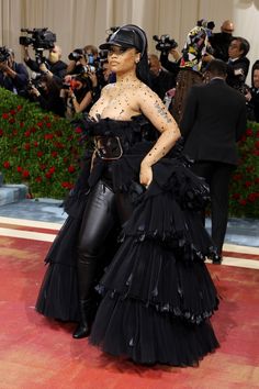 lady in black dress with lots of cameras around her and people taking pictures on the red carpet