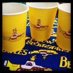 yellow cups sitting on top of a blue table cloth