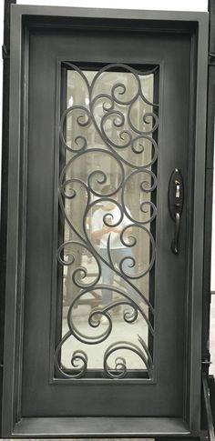 an ornate iron door with glass panels