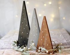 three wooden christmas trees sitting on top of a table