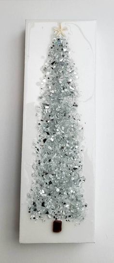 a small white christmas tree with silver tinsel on it