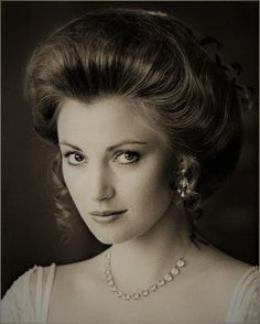 an old photo of a woman wearing pearls