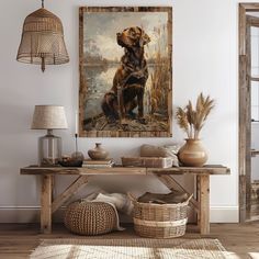 a dog sitting on the ground in front of a painting hanging above a wooden table