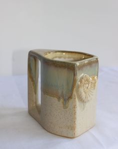 a ceramic mug sitting on top of a white table