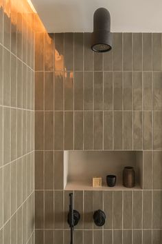 a bathroom with tiled walls and shelves on the wall