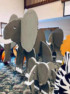 some paper cut out elephants and zebras on the floor in a room with carpet