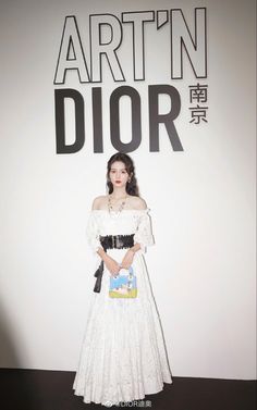 a woman standing in front of a sign with the words art'n dior on it