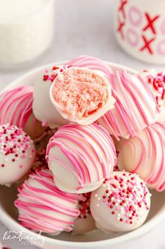 a bowl filled with white and pink candy covered in sprinkles on top of a table