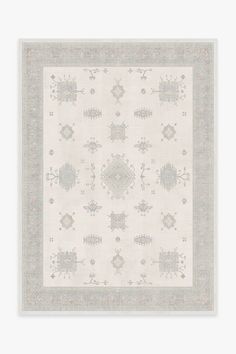 a white rug with an intricate design on the top and bottom, in grey tones