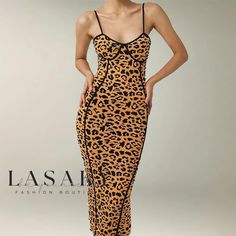 a woman in a leopard print dress posing for the camera