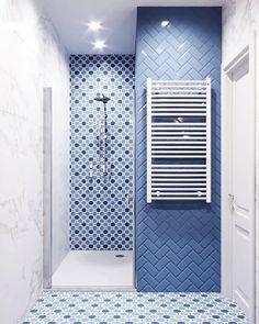 a bathroom with blue and white tiles on the walls, shower stall and towel rack