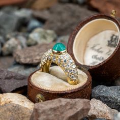 This beautiful ring is centered with one (1), bezel set, round cabochon cut natural emerald. The emerald is heavily included and shows natural surface reaching inclusions. The top half of the ring is accented with forty-eight (48), bead set, round brilliant cut diamonds. The ring measures 6.8mm at the top, rises 8.1mm above the finger, tapering to 3.1mm wide and 1.2mm thick at the base of the shank. Signed Tambetti. The ring is currently a size 4.75. Luxury Green Domed Ring, Luxury Round Emerald Ring With Bezel Setting, Fine Jewelry Emerald Diamond Cabochon Ring, Luxury Emerald Ring With Oval Cabochon Center Stone, Emerald Ring With Oval Cabochon Center Stone, Emerald Oval Cabochon Ring With Center Stone, Oval Cabochon Emerald Ring With Center Stone, Heirloom Style Emerald Ring With Cabochon Cut, Heirloom Emerald Ring With Cabochon Cut