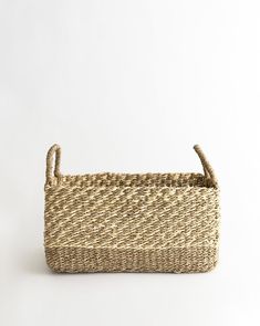 a woven basket with handles on a white background