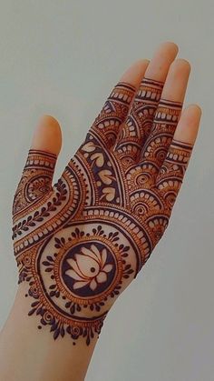 the hand is decorated with henna and flowers on it's palm, as well as an intricate design