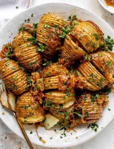 a white plate topped with potatoes covered in sauce