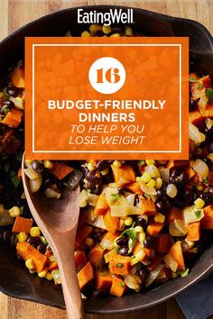 a skillet filled with vegetables on top of a wooden table next to a spoon