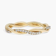 a yellow gold ring with white diamonds on the sides and an intertwined design in the middle