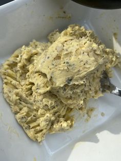 a white bowl filled with food next to a spoon