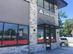 the outside of a restaurant with red and black trim on the front door, and windows