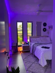 a bed room with a neatly made bed and purple lighting