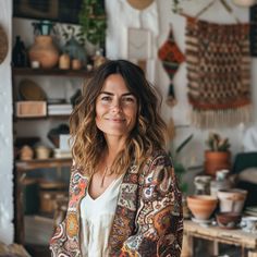 a woman standing in a room with lots of plants and decorations on the wall behind her