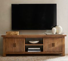 a flat screen tv mounted to the side of a wooden entertainment center