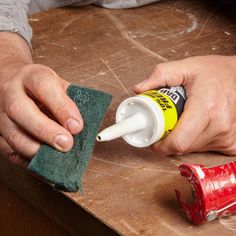 a person using a sponge to clean a table