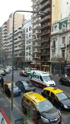 a busy street filled with lots of traffic next to tall buildings on either side of the road