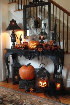 a staircase decorated for halloween with pumpkins, candles and other decorations on the table