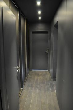 an empty hallway with two doors leading to another room