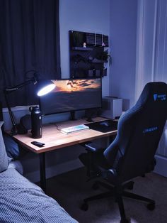 a computer desk with a monitor, keyboard and mouse on it in front of a window