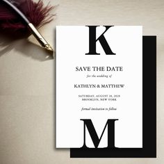 a black and white wedding save the date card with a feather quill on it