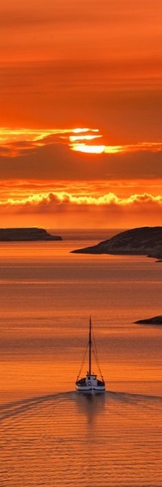 a boat is out on the water at sunset