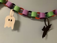 a paper chain with a ghost hanging from it's side next to a halloween decoration