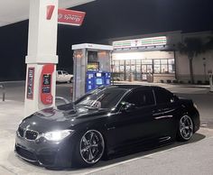 a black car parked in front of a gas station