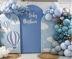 baby shower decoration with balloons and blue decorations on the wall, including hot air balloons